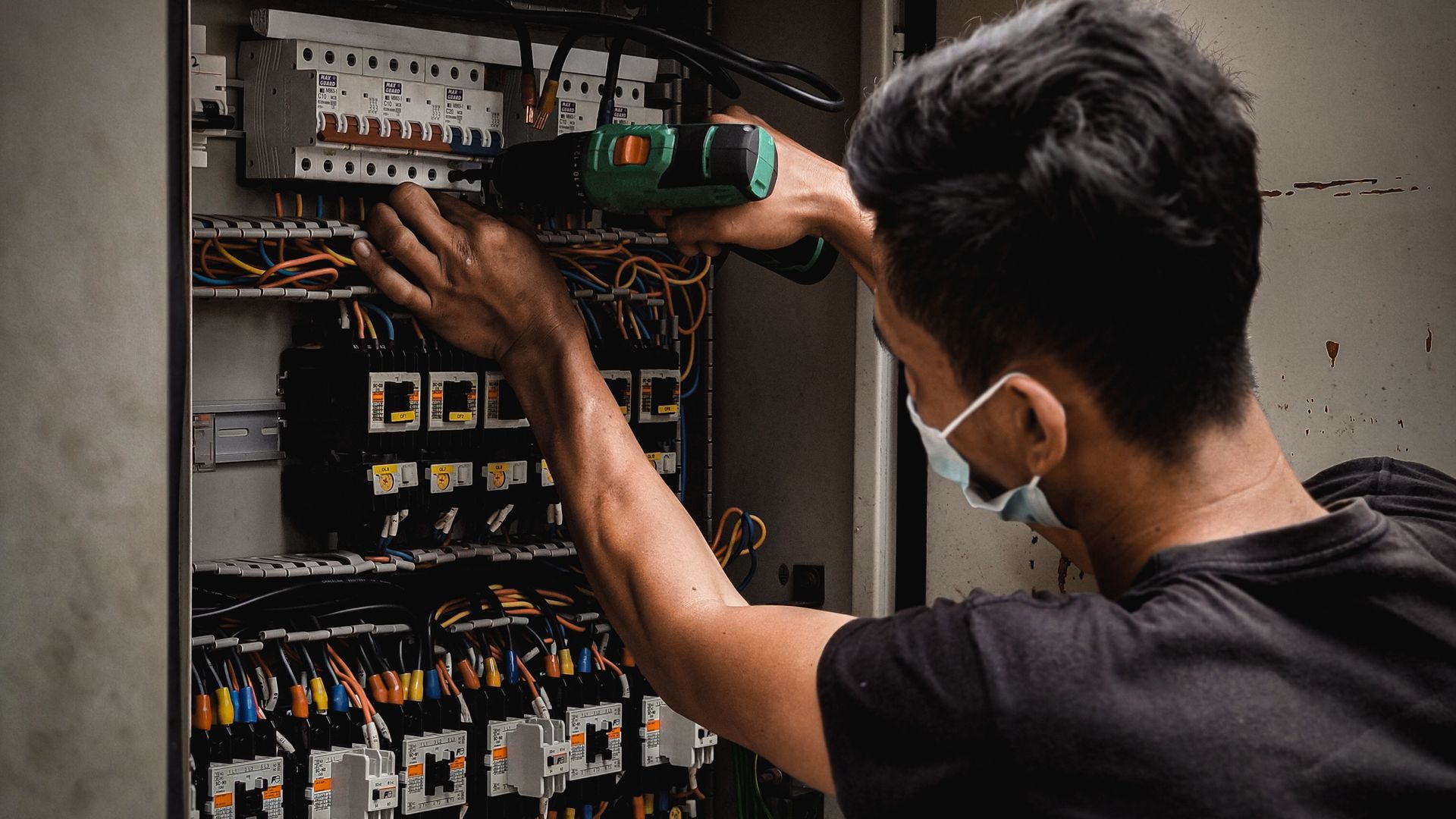 Electricista conectando los magnetotérmicos de un cuadro eléctrico